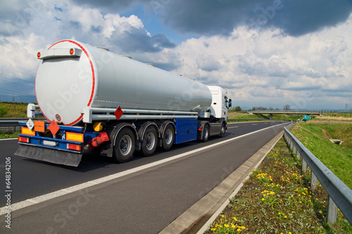 A tanker truck on the highway leading through the countryside