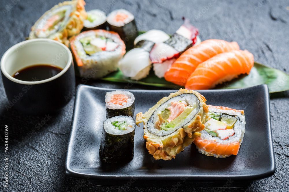 Fresh sushi on the black ceramic dish Fresh sushi on the black ceramic dish