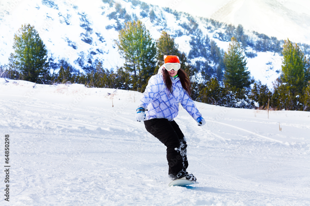 Girl in ski mask sliding with snowboard