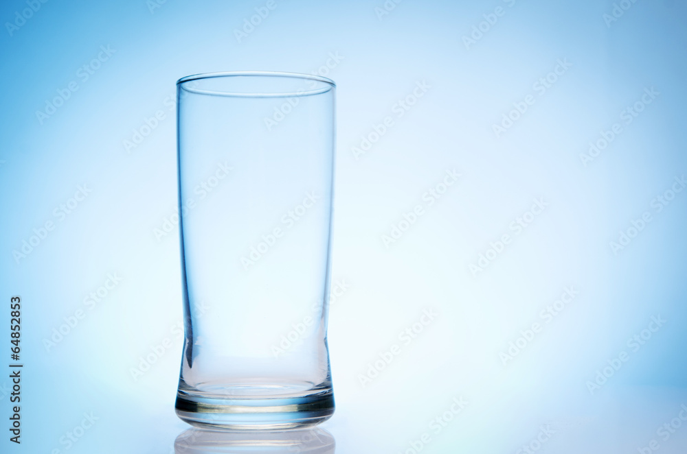 tall empty glass of water on bluebackground tall empty glass of water on bluebackground
