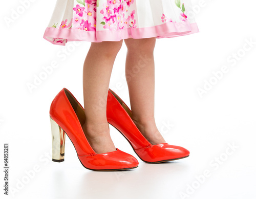 Little girl in big mommy shoes isolated on white