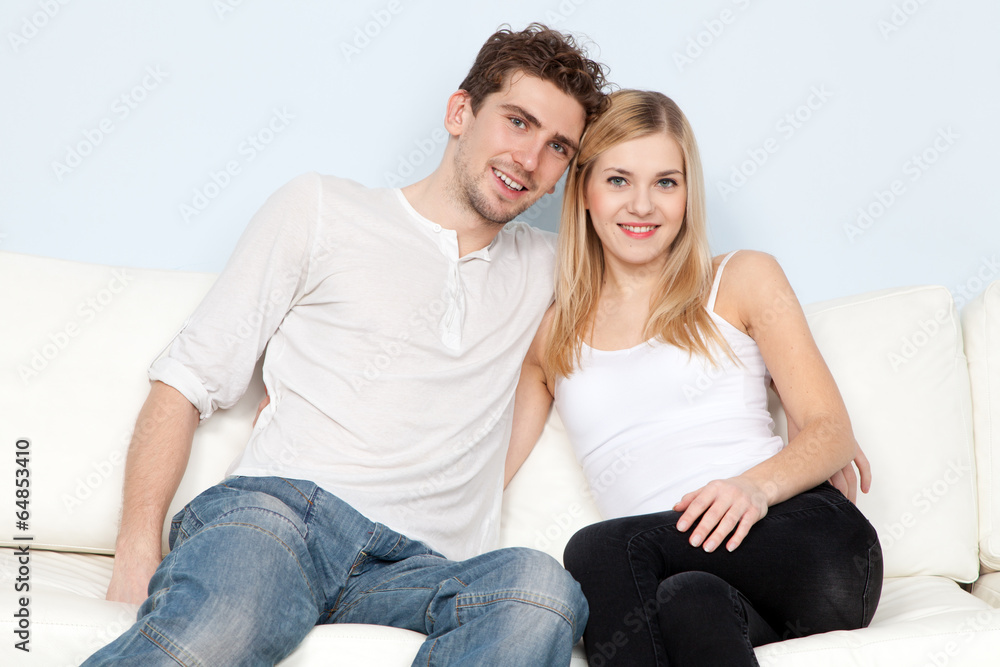 Young beautiful couple on a sofa at home