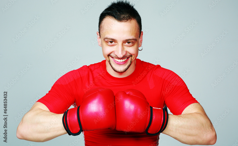 Portrait of a boxer with his gloves together on gray background