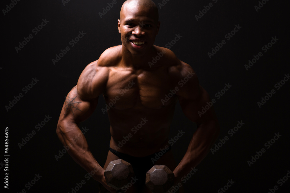 muscular man training with dumbbells