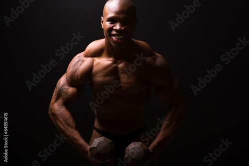 muscular man training with dumbbells