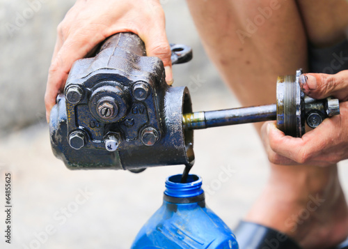 Auto mechanic hand holding motor oil