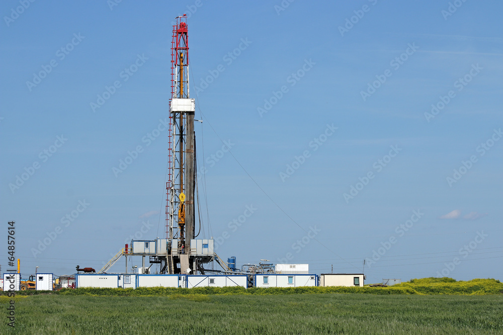 land oil drilling rig on green field landscape