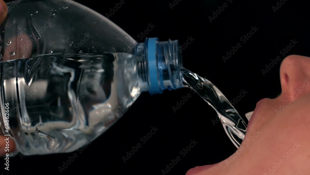 Woman pouring water into her mouth Woman pouring water into her mouth