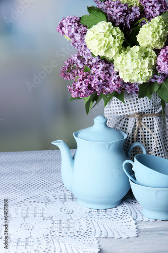 Composition with tea set and beautiful spring flowers in vase,