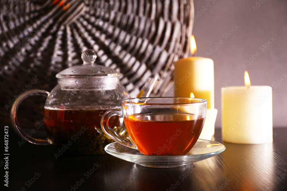Composition with tea in glass teapot and candles Composition with tea in glass teapot and candles