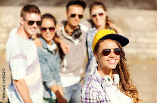 teenage girl with headphones and friends outside