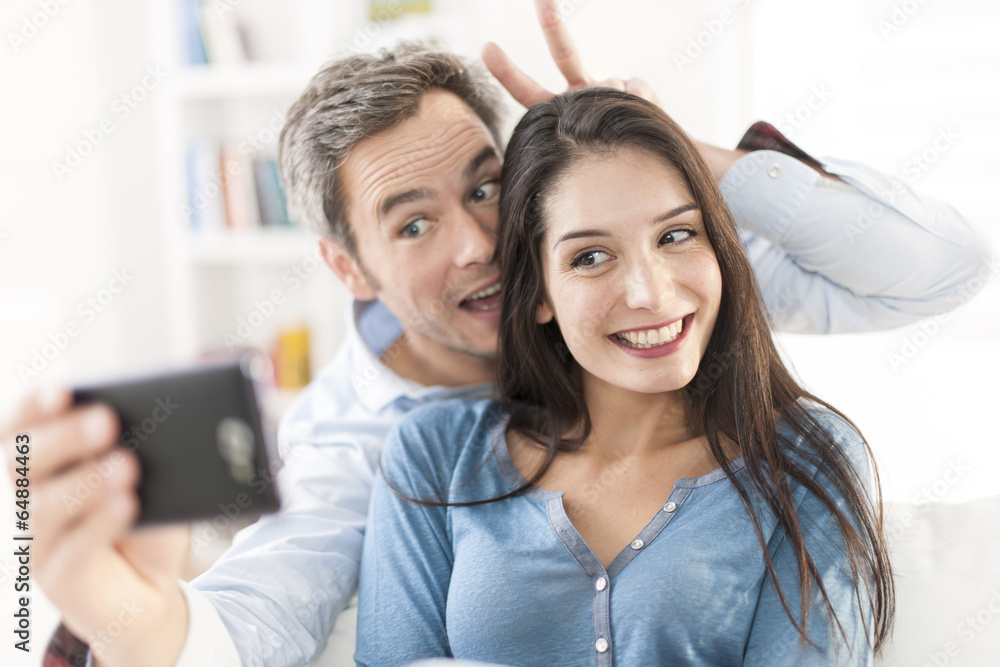 cheerful couple taking a humoristic selfie with a smartphone