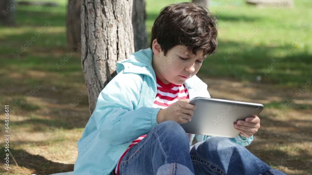 Child using digital tablet in park Child using digital tablet in park