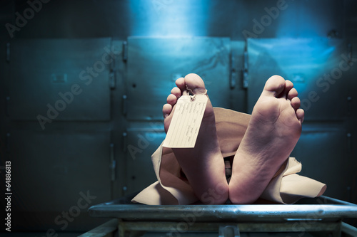 Feet on a morgue table with toe tag with dramatic lighting