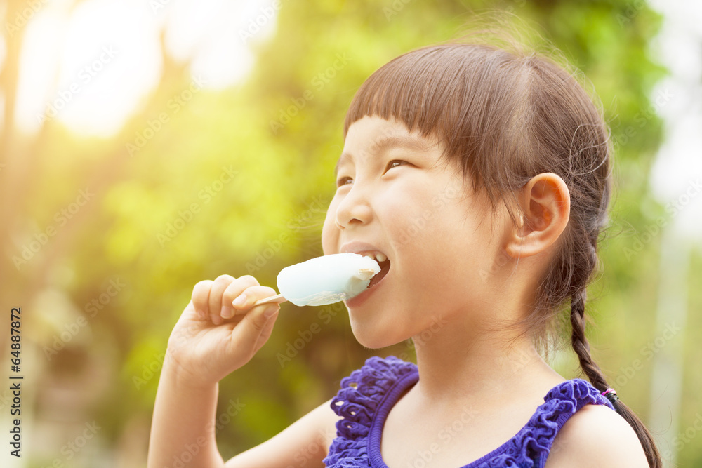 happy little girl eating popsicle at summertime with sunset happy little girl eating popsicle at summertime with sunset