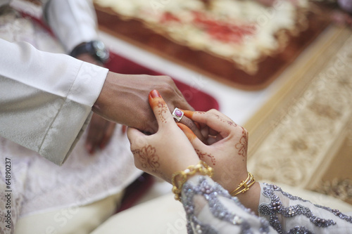picture of woman putting wedding ring on man hand