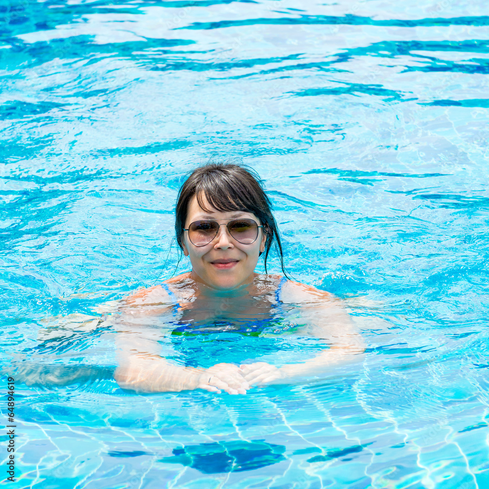 Portrait of a beautiful young girl in the pool