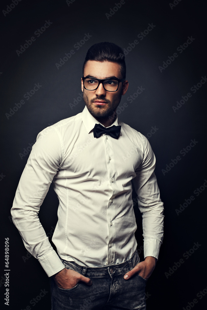 Handsome man with eyeglasses posing in studio on dark background Handsome man with eyeglasses posing in studio on dark background