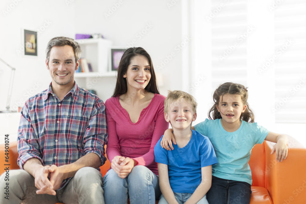family sitting on a sofa in her living room family sitting on a sofa in her living room