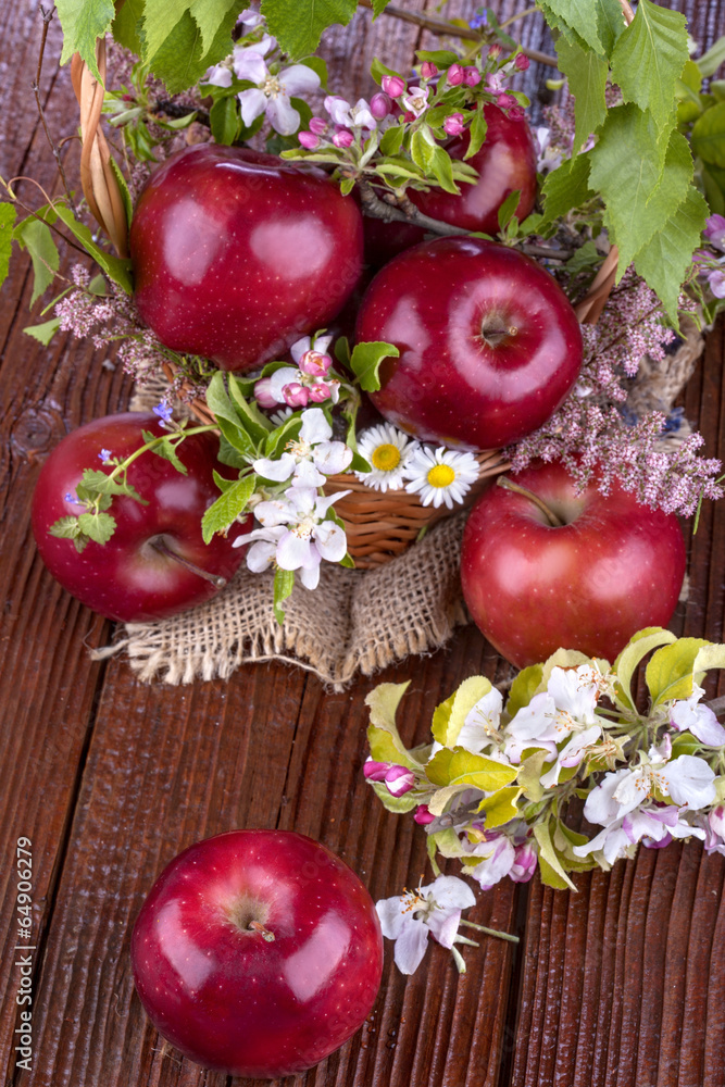 apples in a basket with flowers on wooden table apples in a basket with flowers on wooden table