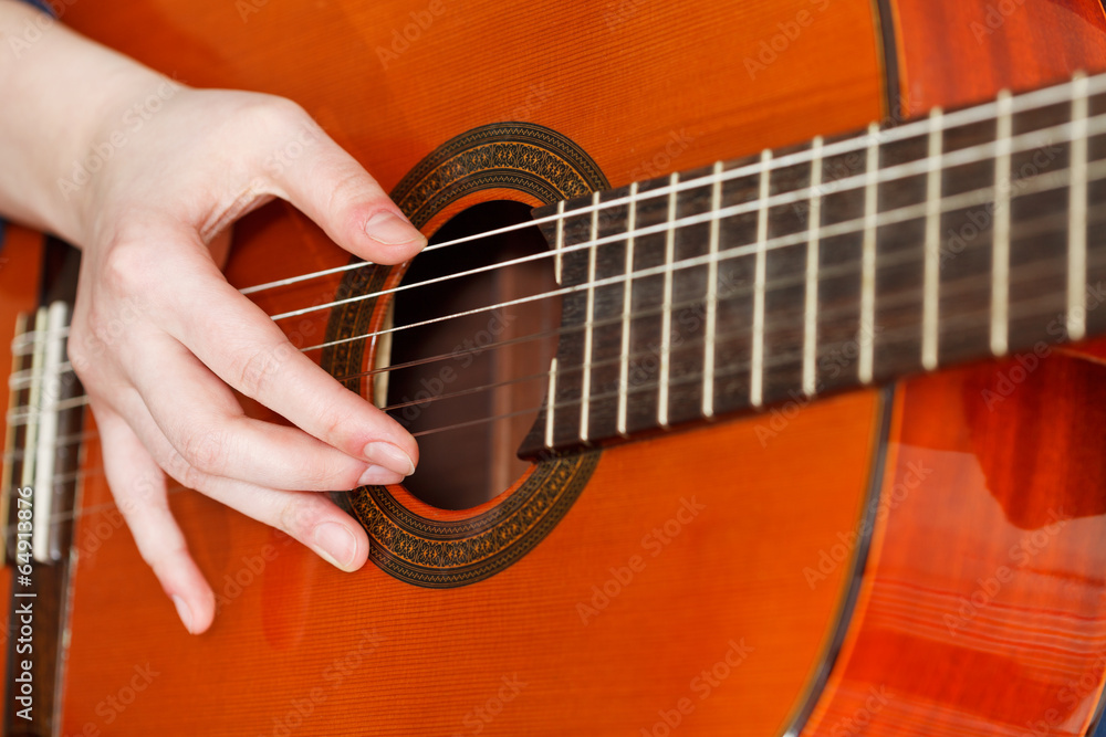 Fototapeta premium female hand playing acoustic guitar