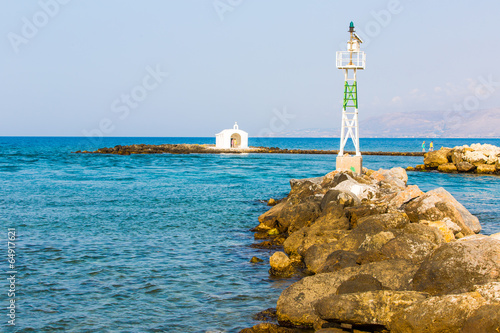 Old venetian lighthouse at harbor in Crete, Greece.