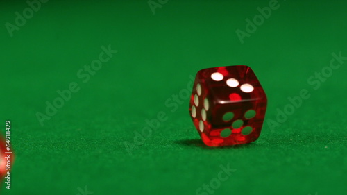 Red dice rolling on casino table