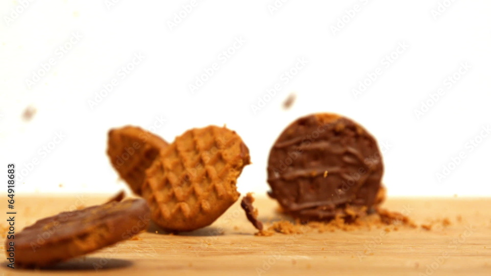 Biscuits falling and breaking on wooden table