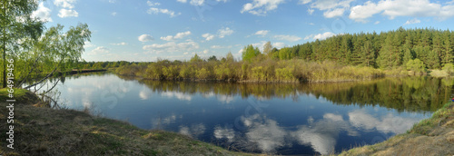 May panorama quiet forested river.