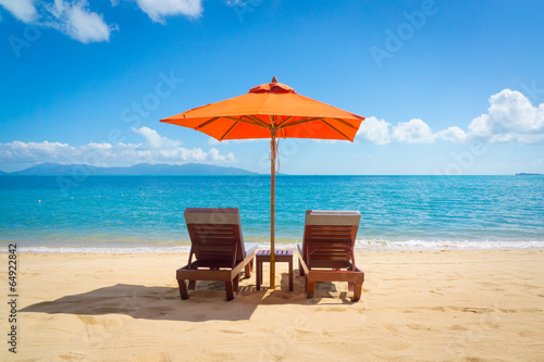 Fotografia Two lounge chairs on the beach