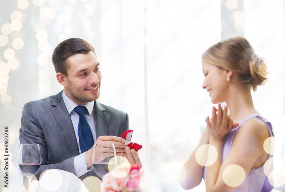 man proposing to his girlfriend at restaurant man proposing to his girlfriend at restaurant