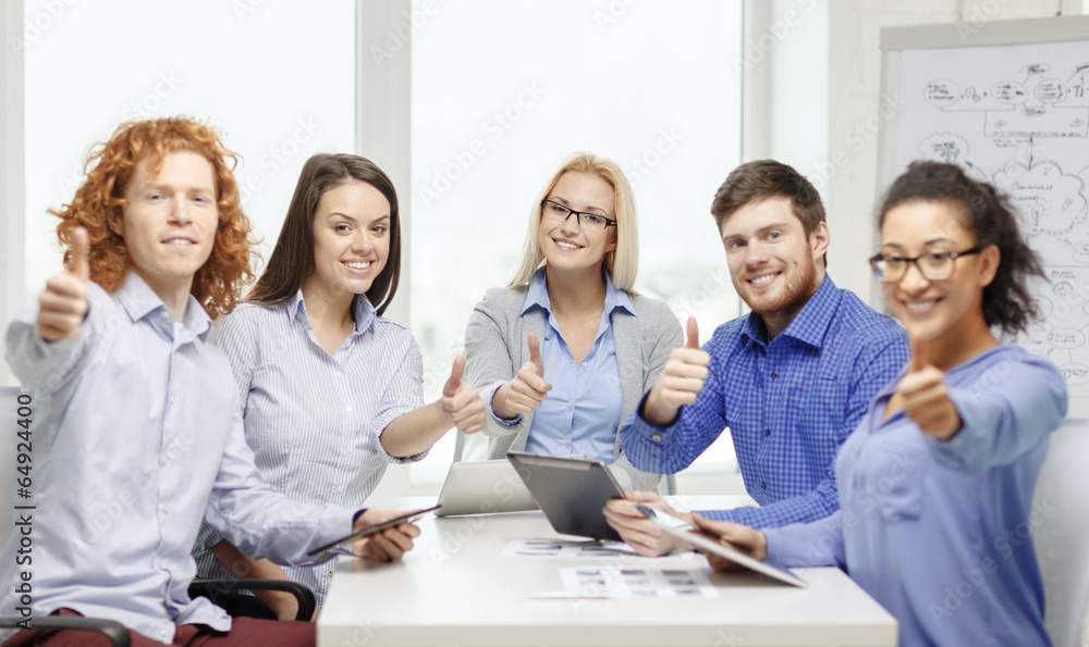 smiling team with table pc and papers working smiling team with table pc and papers working
