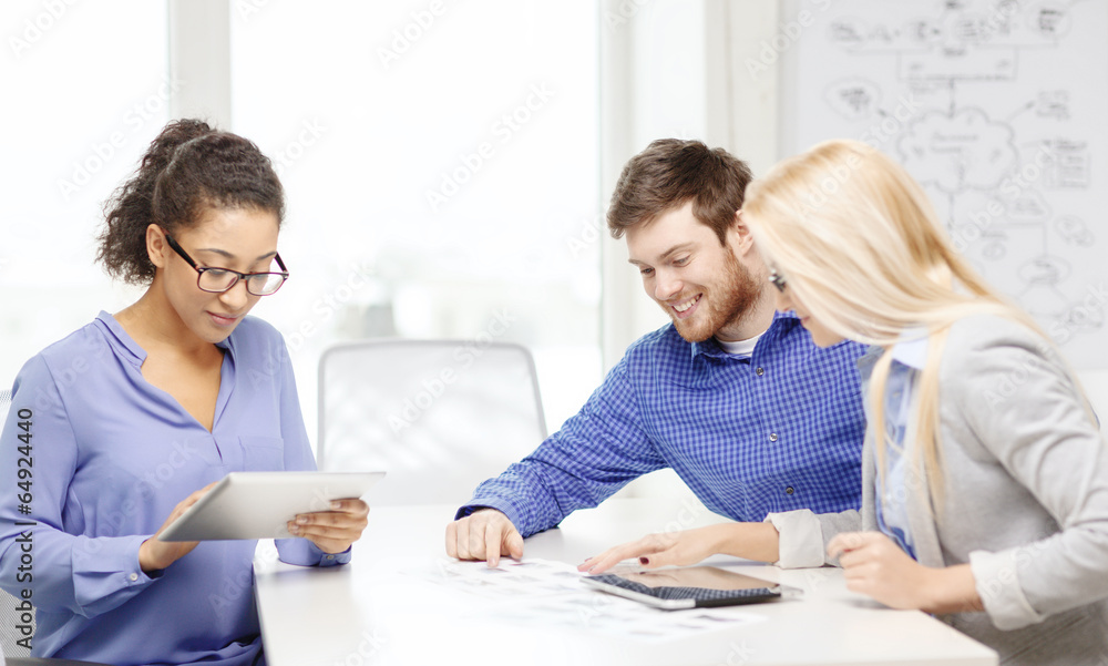 smiling team with table pc and papers working smiling team with table pc and papers working