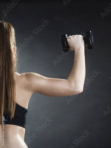 Girl training shoulder muscles lifting dumbbells back view