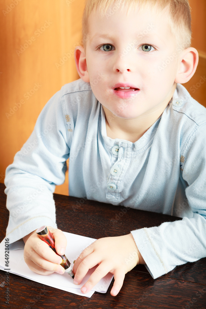 Boy child kid drawing with marker on piece of paper. At home. Boy child kid drawing with marker on piece of paper. At home.