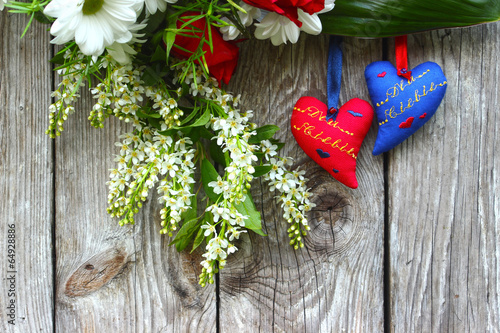 Dwa serca i kwiaty na drewnianym tle