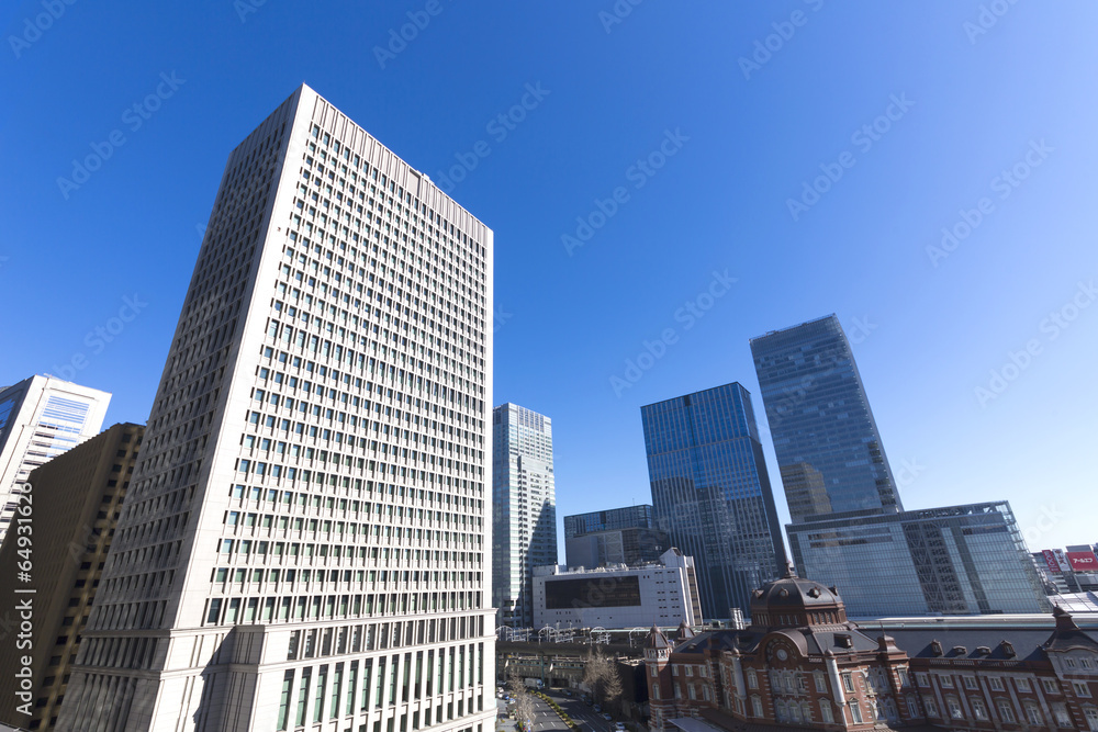 透き通るような青空の東京駅と周辺高層ビル街 イメージ