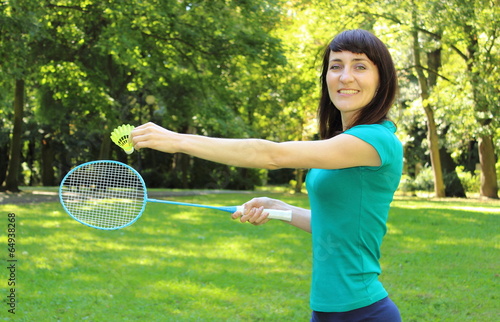 Smiling woman playing badminton in the summer park © ratmaner