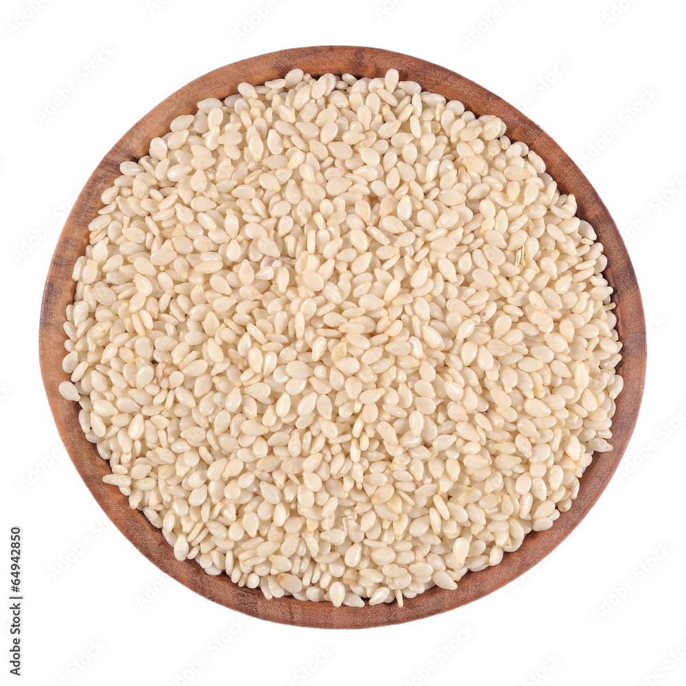 Sesame seeds in a wooden bowl on a white Sesame seeds in a wooden bowl on a white