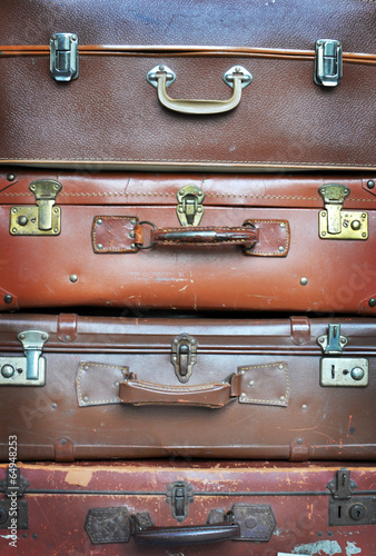 Vecchie valigie in pelle impilate in verticale photo