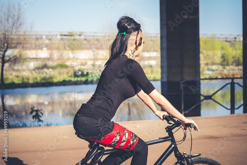 young beautiful punk dark girl riding bike