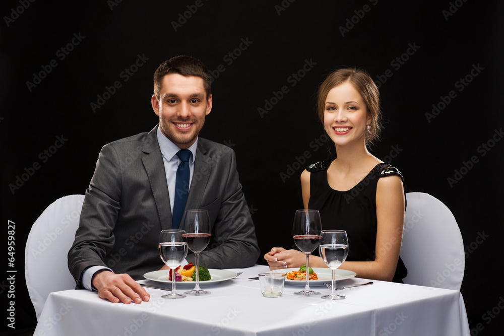 smiling couple eating main course at restaurant