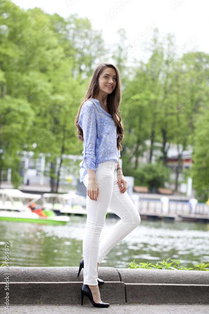Full length portrait of a beautiful woman in white pants and blu