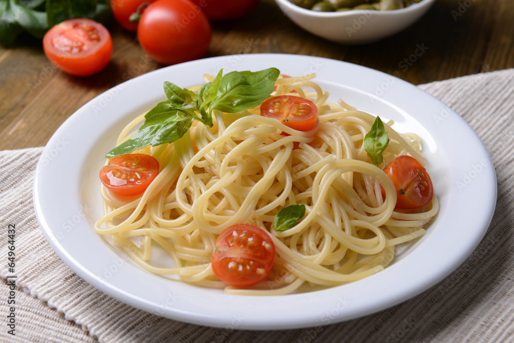 Delicious spaghetti with tomatoes on plate on table close-up Delicious spaghetti with tomatoes on plate on table close-up