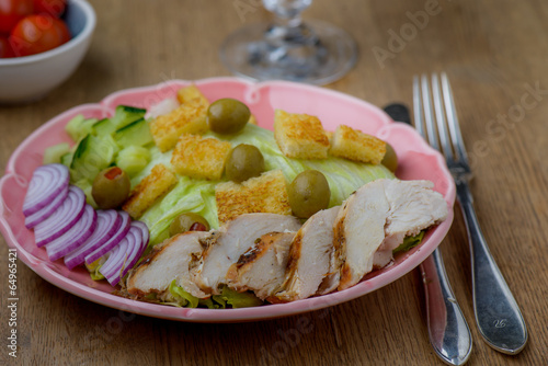 Chicken salad with tomatoes in the background on wood table