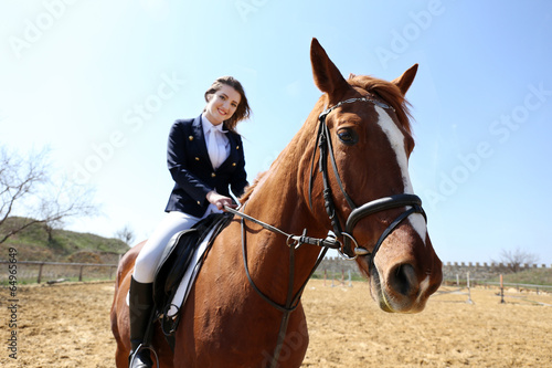 Beautiful girl riding a horse outdoors