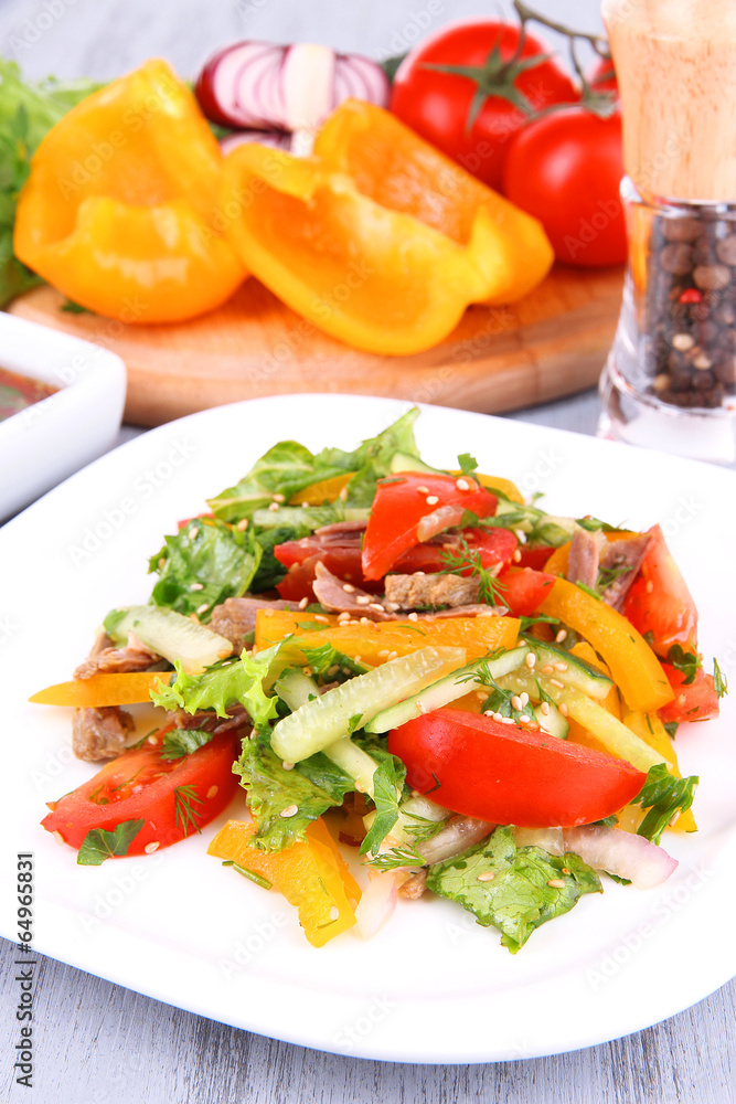 Beef salad on plate with vegetables and spices on wooden table Beef salad on plate with vegetables and spices on wooden table