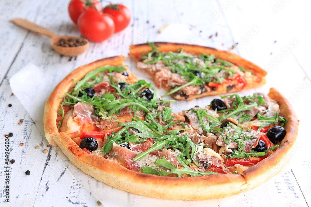 Pizza with arugula on color wooden background Pizza with arugula on color wooden background