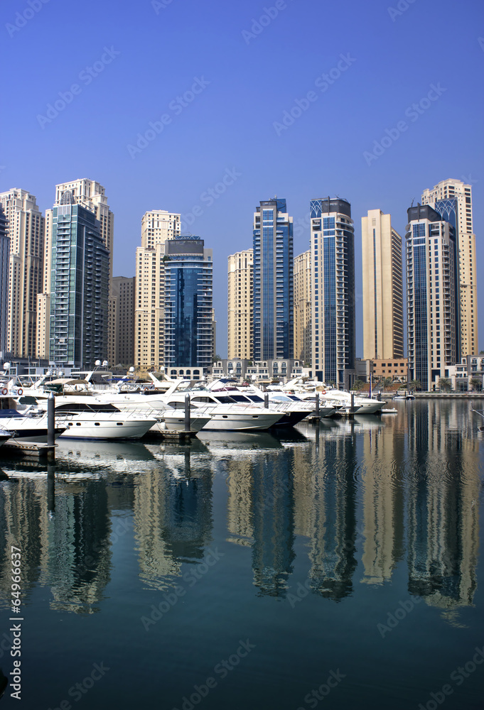 dubai marina with yaghts and residential tower view from bridge