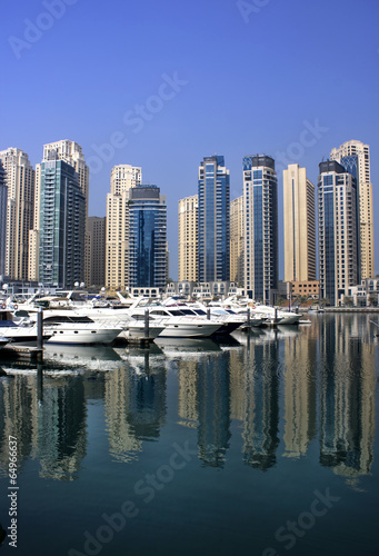 dubai marina with yaghts and residential tower view from bridge photo